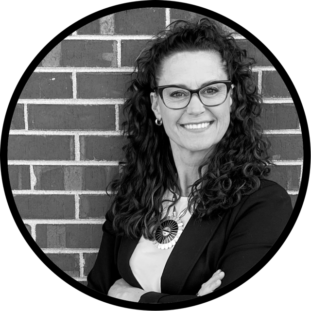 Color photo of Julie Moon smiling in front of a brick wall